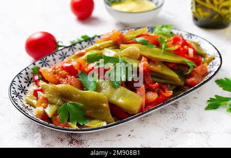 Hausgemachte gedünstete grüne Bohnen, Tomaten, Knoblauch mit Olivenöl. Zeytinyagli fasulye traditionelle Speisen. Türkische Küche. Stockfoto