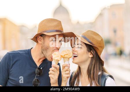 Glückliches Paar, das in Rom, Italien, Eis isst. Wunderschönes, helles Eis mit verschiedenen Geschmacksrichtungen in den Händen eines Paares Stockfoto