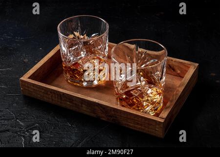 Whiskey in Gläsern mit Eis, Bourbon Whisky auf Felsen auf dunklem Hintergrund, serviert für zwei Stockfoto