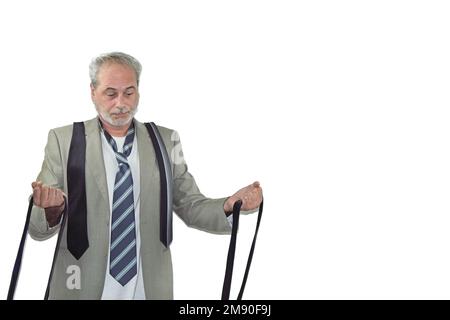 Ein erwachsener Mann mit Bart im Anzug, der viele Krawatten auf weißem Hintergrund sieht Stockfoto