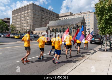 Männer und Frauen tragen leuchtend gelbe T-Shirts, die auf den Straßen von Downtown Nashville, Tennessee, laufen. Stockfoto