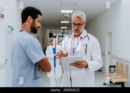 Ärzte diskutieren etwas auf dem Krankenhausflur. Stockfoto
