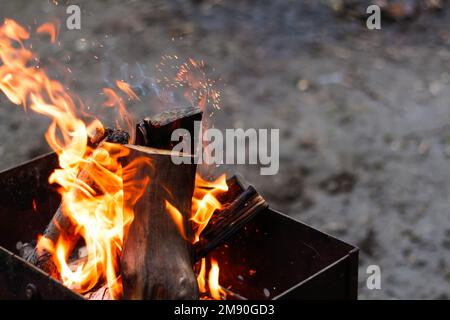 Unschärfe Feuer Flamme Holz Kamin Holz. Helle Flammen verbrennen Holz auf schwarzem Hintergrund. Lagerfeuer in der Nacht. Kaltes Wetter in Europa. Aus Stockfoto