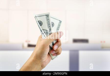 Nahaufnahme eines Mannes, der in der Bank ein Bündel Hundert-Dollar-Scheine zerquetscht Stockfoto