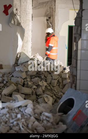 Mainz, Deutschland. 16. Januar 2023. Eine Frau geht bei einem Rundgang durch die Baustelle des Rathauses an Schutt vorbei. Das Rathaus wird derzeit renoviert. (An dpa 'Mainzer Rathaus demontiert und gelagert') Kredit: Sebastian Christoph Gollnow/dpa/Alamy Live News Stockfoto