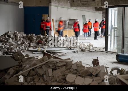 Mainz, Deutschland. 16. Januar 2023. Journalisten und Mitarbeiter gehen bei einer Führung durch die Baustelle des Rathauses an Schutt vorbei. Das Rathaus wird derzeit renoviert. (An dpa 'Mainzer Rathaus demontiert und gelagert') Kredit: Sebastian Christoph Gollnow/dpa/Alamy Live News Stockfoto