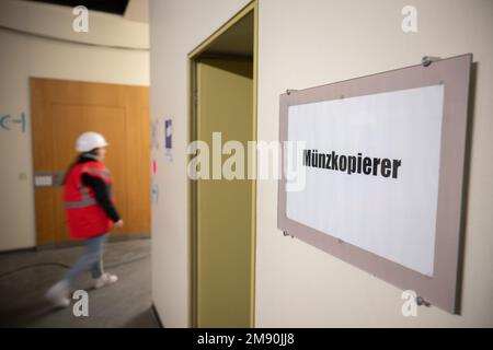 Mainz, Deutschland. 16. Januar 2023. Eine Frau geht an einem Schild mit der Aufschrift „Münzkopierer“ vorbei, während sie die Baustelle des Rathauses begeht. Das Rathaus wird derzeit renoviert. (An dpa 'Mainzer Rathaus demontiert und eingelagert') Kredit: Sebastian Christoph Gollnow/dpa/Alamy Live News Stockfoto