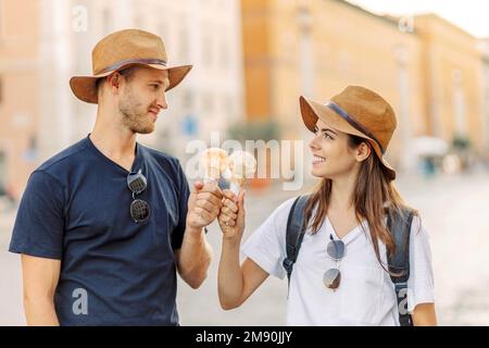 Glückliches Paar, das in Rom, Italien, Eis isst. Wunderschönes, helles Eis mit verschiedenen Geschmacksrichtungen in den Händen eines Paares Stockfoto