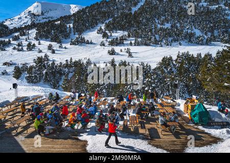 El Tarter, Andorra, 2020. Januar, Leute, die an Tischen sitzen, entspannen und essen mit einer wunderschönen Aussicht auf die verschneiten Berge und den Wald. Winterski-Ferien Stockfoto