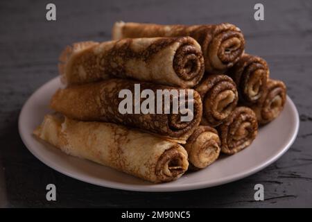 Foto von vielen wunderschön gestapelten, frittierten Pfannkuchen, groß auf einem Teller Stockfoto