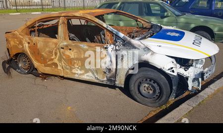 Abgebrannter Polizeiwagen. Vandalismus, verbranntes Auto. Ein Auto nach dem Feuer. Automatischer Papierkorb. Zerstörter Streifenwagen der ukrainischen Nationalpolizei. Übersetzung - Stockfoto