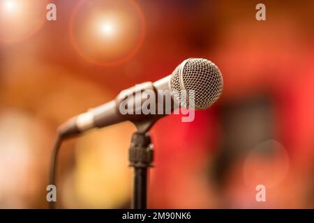 Öffentliche Aufführung auf der Bühne Mikrofon auf der Bühne vor dem Hintergrund der Auditorium. Geringe Tiefenschärfe. Öffentliche Aufführung auf der Bühne. Stockfoto
