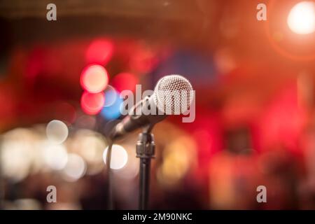 Öffentliche Aufführung auf der Bühne Mikrofon auf der Bühne vor dem Hintergrund der Auditorium. Geringe Tiefenschärfe. Öffentliche Aufführung auf der Bühne. Stockfoto