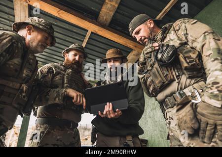 Eine Gruppe von Soldaten, die vor dem Kampf etwas besprechen Stockfoto