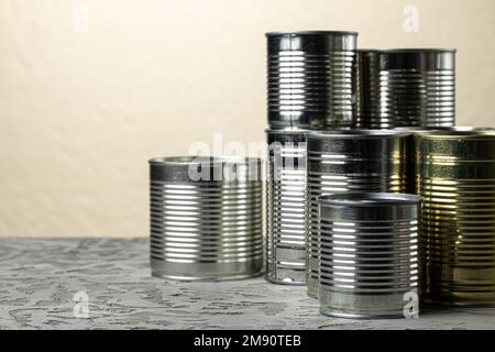 Viele Dosen zu den Mahlzeiten wie Fleisch und Fisch auf dem Tisch, konservierte Lebensmittel Stockfoto