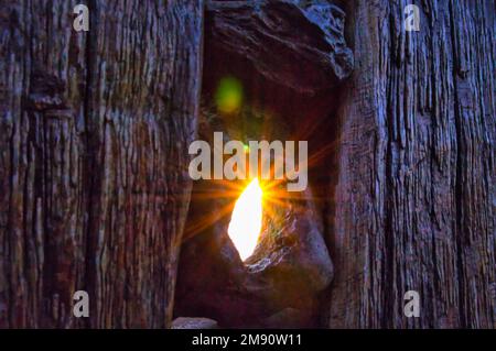 Sonnenstrahlen, die durch ein Loch in der Boje leuchten. Am Ostseestrand bei Zingst Stockfoto