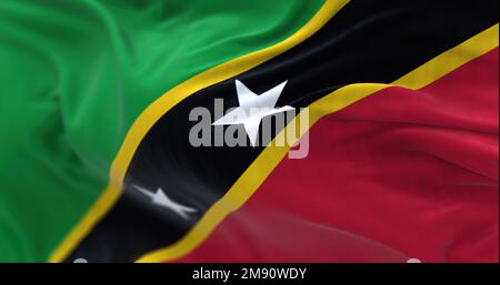 Die Nationalflagge von St. Kitts und Nevis winkt. St. Kitts and Nevis Federation ist ein Inselstaat in Mittelamerika. Geriffelter Stoff. Strukturierter Hintergrund Stockfoto