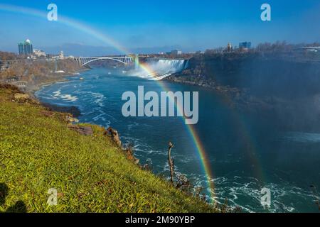 Ein Luftbild der Niagarafälle und ein Regenbogen darüber unter dem blauen Himmel, Kanada Stockfoto