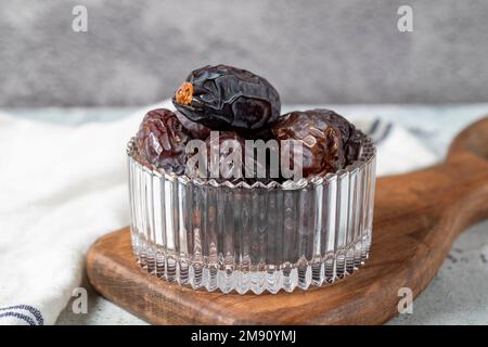 Jerusalem Dattelfrucht auf Steinhintergrund. Getrocknete Dattelfrucht in einer Glasschüssel. Ramadan-Essen. Gesunde Ernährung. Schließen Stockfoto