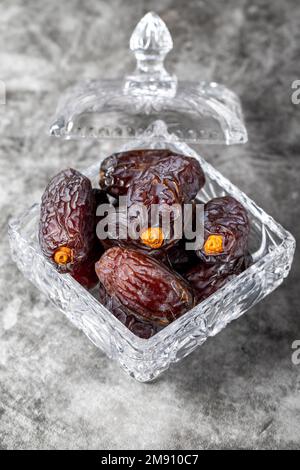 Jerusalem Dattelfrucht auf Steinhintergrund. Getrocknete Dattelfrucht in einer Glasschüssel. Ramadan-Essen. Gesunde Ernährung. Schließen Stockfoto