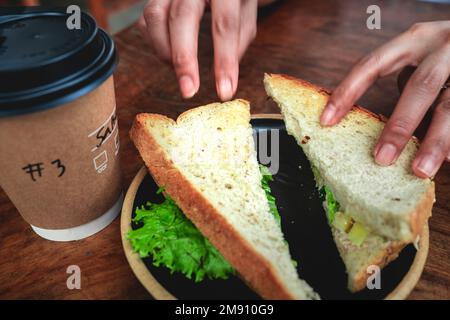 Ein kurzer Happen Sandwich mit Kaffee für den Start in den Tag. Stockfoto