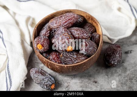 Jerusalem Dattelfrucht auf Steinhintergrund. Riesige Dattelfrucht in einer Kokosnussschale. Ramadan-Essen. Gesunde Ernährung. Schließen Stockfoto