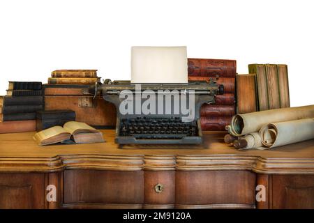 Ein alter Holzschreibtisch mit einer alten Schreibmaschine, auf der ein leeres Blatt Papier und alte Bücher und Karten stehen Stockfoto