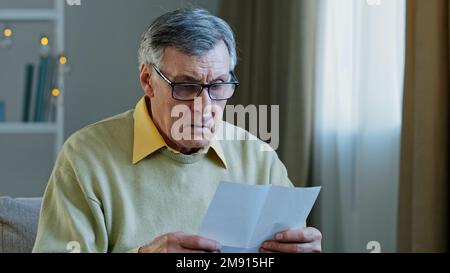 Enttäuscht traurig verärgert schockierter weißer alter Mann erhalten offizielle Bankbenachrichtigung Ablehnung lesen schlechte Nachrichten in Brief Insolvenz Schuldenproblem Gefühl Stockfoto