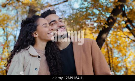 Ethnisch multirassisches Ehepaar im Herbstpark glücklich lächelnde kaukasische Frau mit hispanischem Mann im Freien Kerl und Mädchen Freund und Freundin Look Stockfoto