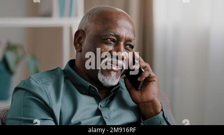 Afrikanischer Geschäftsmann mittleren Alters Senior reifer Geschäftsmann Unternehmer zu Hause im Büro sprechen Telefon chatten mobile Unterhaltung Buchungsauftrag Stockfoto