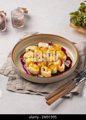 Faule Knödel mit Vanille und Kirschsoße Stockfoto