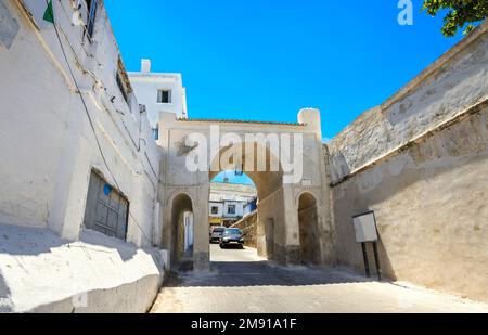 Blick auf die Straße mit Tor zur antiken Medina in Tanger. Marokko, Nordafrika Stockfoto