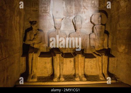 Statuen von Ptah, Amun Ra, König Ramesses II. Und Ra-Horakhty, beleuchtet von den Sonnenstrahlen im Großen Tempel von Ramesses II. In Abu Simbel, Ägypten Stockfoto