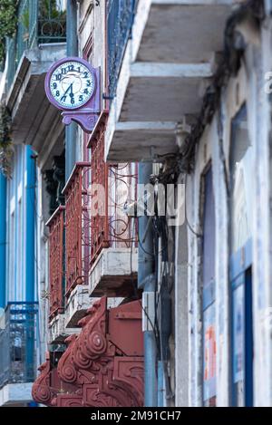 Alte, verfallene Uhr an der Wand auf einem Apartmentgebäude im klassischen portugiesischen Stil mit traditionellen Fliesen in Lissabon, Portugal Stockfoto