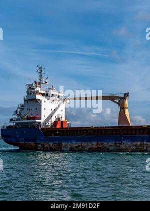 Cobh, Irland, 10. August 2022. Ein altes rostiges, großes Schiff segelt auf dem Meer, blauer Himmel. Frachtschiff auf See. Blau-weißes Schiff auf See unter klarem Himmel. Stockfoto