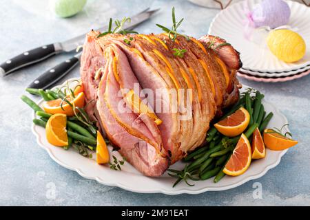 Osterschinken gefüllt mit Orangenscheiben, glasierter Schinken in Spiralscheiben Stockfoto