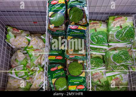 Italien - 12. Januar 2023: Packungen mit gefrorenem Blumenkohl und Erbsen in einer Kühltheke zum Verkauf im italienischen Supermarkt Stockfoto