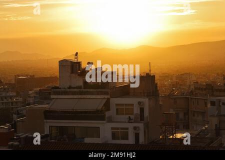 Dächer der griechischen Hauptstadt Athen am Abend bei Sonnenuntergang. Stadtbild, Dächer und Berge. Griechenland, Südeuropa, Reiseziel, Urlaub, U Stockfoto