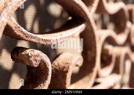 Selektivfokus eines rostigen Eisenfensters mit kreisförmigen und spiralförmigen Formen Stockfoto