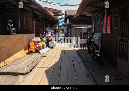 Georgetown, Penang, Malaysia - November 2012: Ein hölzerner Fußweg durch traditionelle Pfahlbauten in den Clan-Anlegestegen eines am Wasser gelegenen Dorfes in George T. Stockfoto