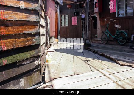 Georgetown, Penang, Malaysia - November 2012: Ein hölzerner Fußweg durch traditionelle Pfahlbauten in den Clan-Anlegestegen eines am Wasser gelegenen Dorfes in George T. Stockfoto