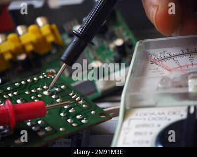 Prüfung von elektronischen Leiterplatten oder Fehlersuche mit einem Multimeter. Hintergrund der Elektronikindustrie. Stockfoto