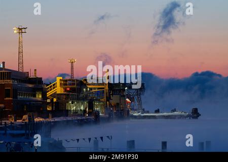 Helsinki, Finnland - 15. Januar 2021: Docks und Terminals des Hafens von Katajanokka an einem extrem kalten Winteraufgang mit aufsteigendem Nebel Stockfoto