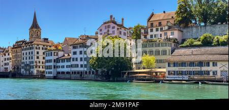 Malerischer Blick auf die Häuser am Schipfe und die Kirche St. Peter am Ufer des Limmat in Zürich, Schweiz Stockfoto