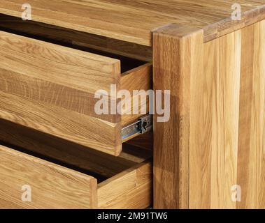 Geöffnete Holzschubladen mit Schiebern, Foto aus nächster Nähe, Holzmöbelelemente Hintergrund. Möbeldetails aus Massivholz Stockfoto