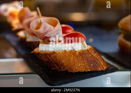 Typischer Mini-Burger-Snack aus dem Baskenland, Pinchos oder Pinxtos, kleines Stück Brot mit verschiedenen Belägen, serviert in der Bar in San-Sebastian oder Bilba Stockfoto