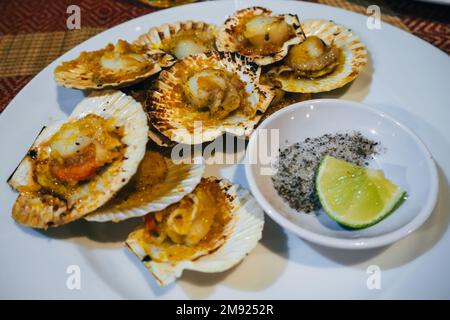 Austern mit scharfer Sauce auf einer Limetten- und Salzplatte für traditionelle asiatische Gerichte Stockfoto