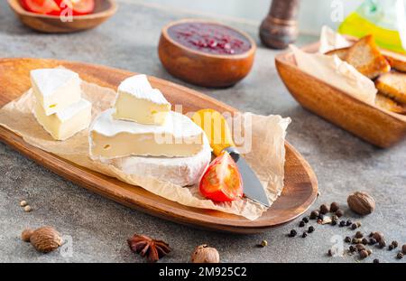 Camembert Käse mit Feigen, Himbeermarmelade. Rundbrie oder Camambert-Käse auf Schneidebrett Stockfoto