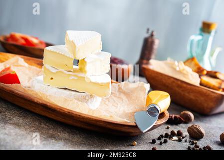 Camembert Käse mit Feigen, Himbeermarmelade. Rundbrie oder Camambert-Käse auf Schneidebrett Stockfoto