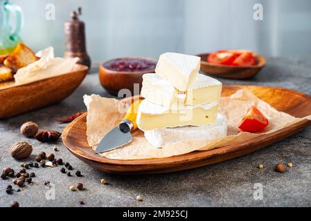 Camembert Käse mit Feigen, Himbeermarmelade. Rundbrie oder Camambert-Käse auf Schneidebrett Stockfoto